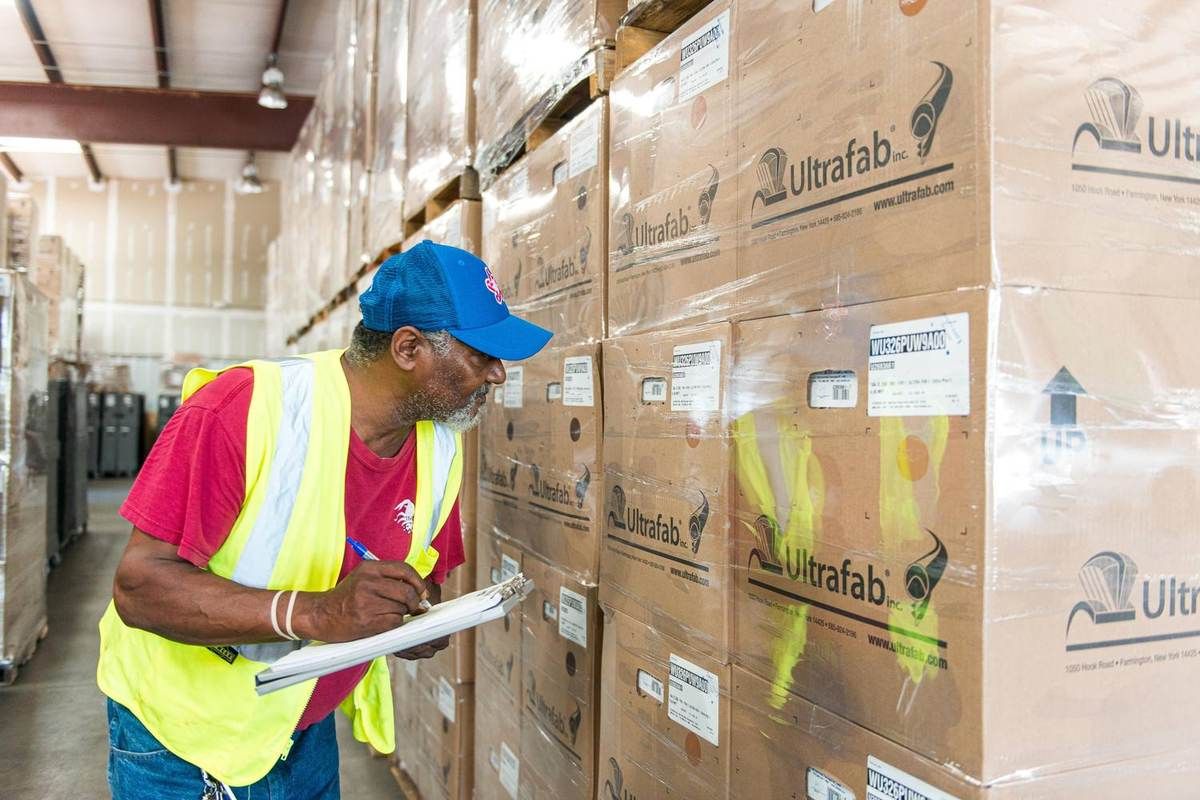 ACME team member checking staged boxes in the warehouse